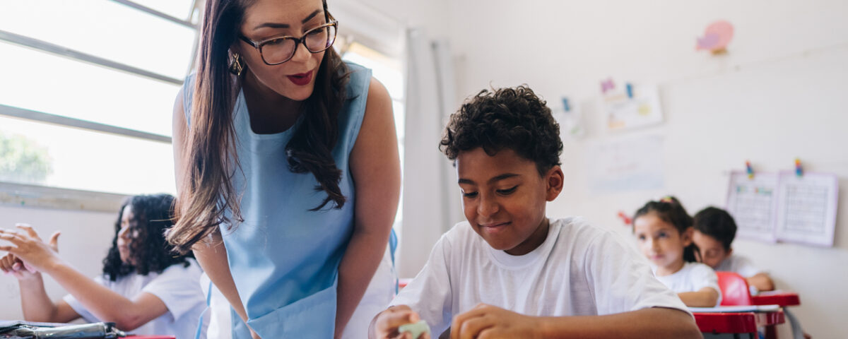 Educators legal liability insurance: Teacher teaching her student on classroom at school